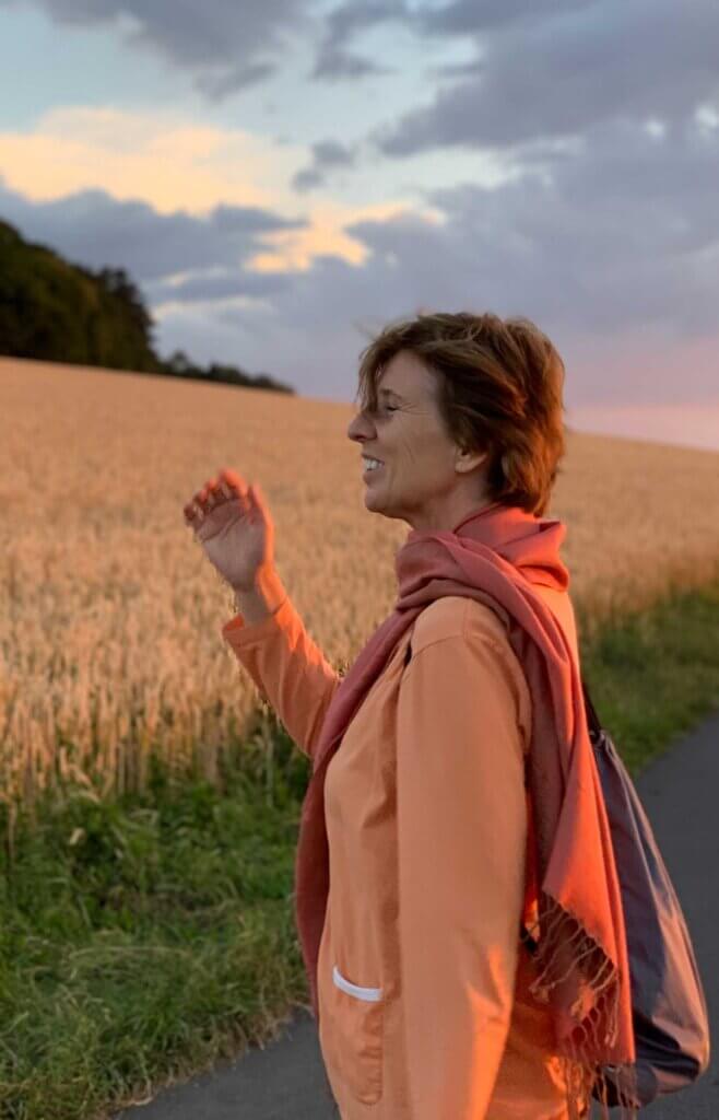 Frauke Schmidt vor einem Getreidefeld blickt nach links